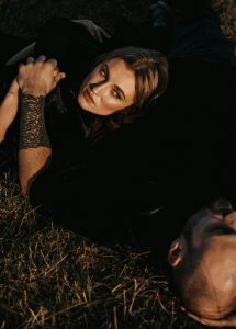 Couple Lying on Grass and Holding Hands